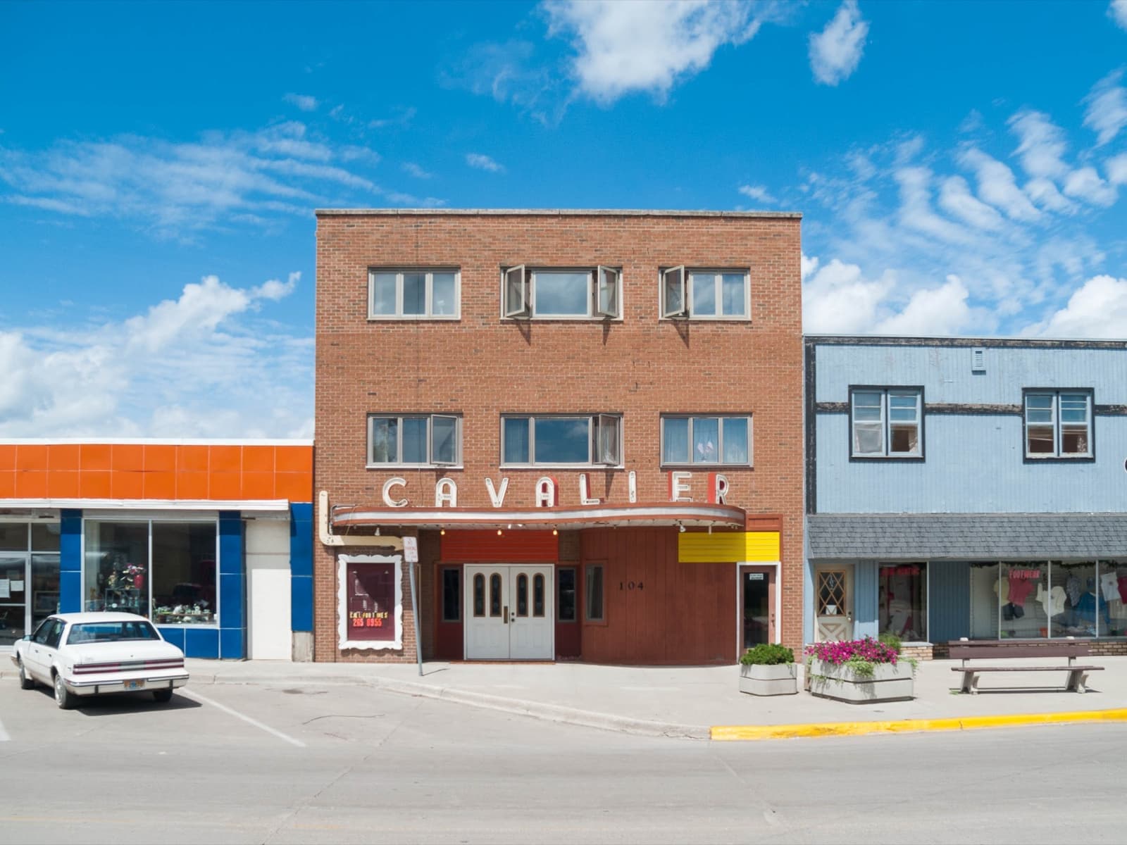 A red-brick building with CAVALIER lettering across its front, under a big blue sky