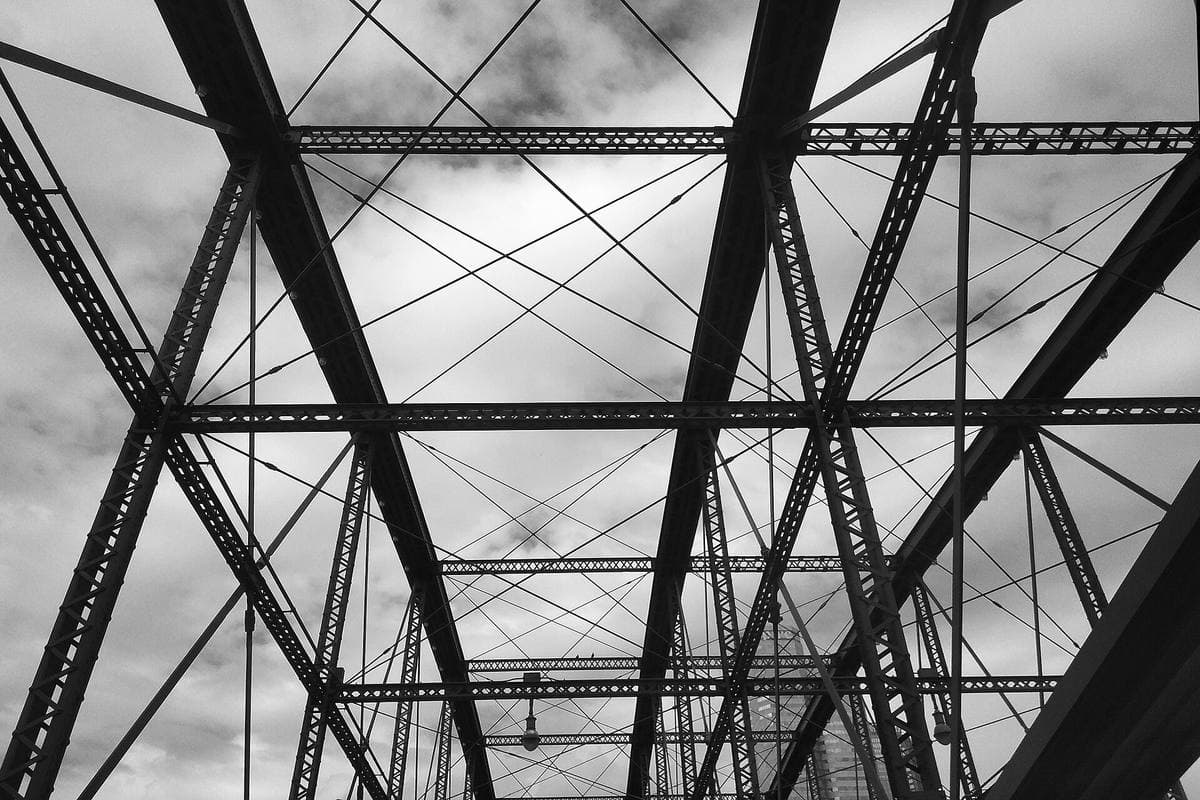 Criss-crossing steel trusses of the Smithfield Street Bridge against a grey sky