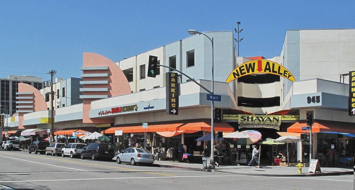 Shops with awnings under a concrete parking building on Wall Street