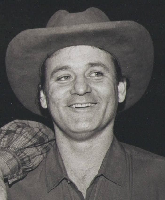 Bill Murray grinning under a cowboy hat, in black and white