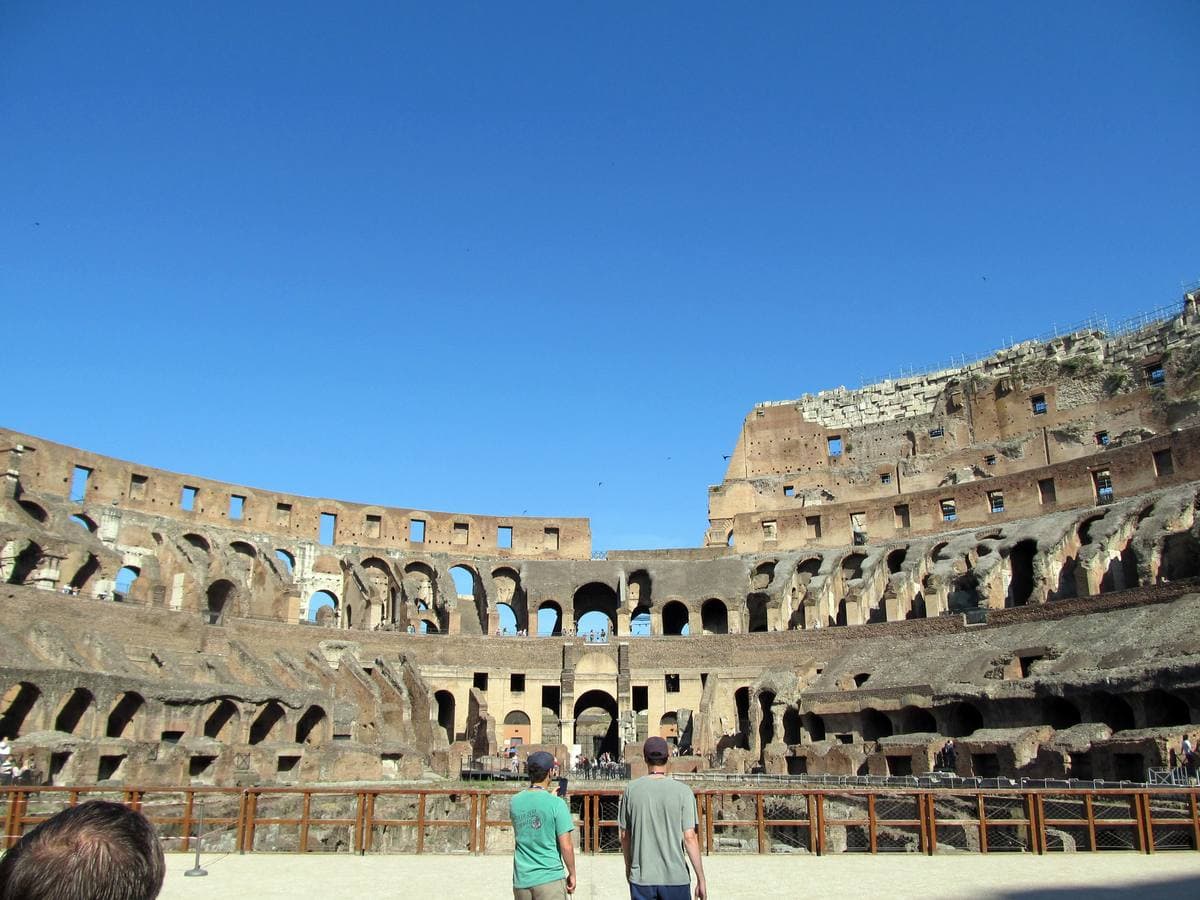 Tiers of broken arches round the Colosseum’s open interior, visitors on a walkway