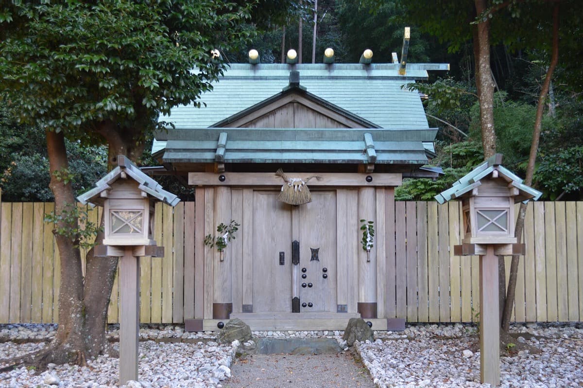 A Shinto shrine building among trees in winter light