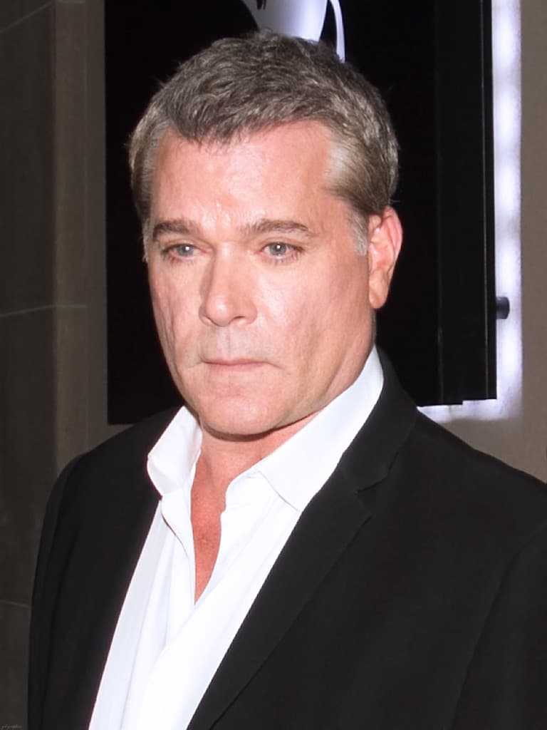 Colour photograph of Ray Liotta in a dark jacket and open white shirt