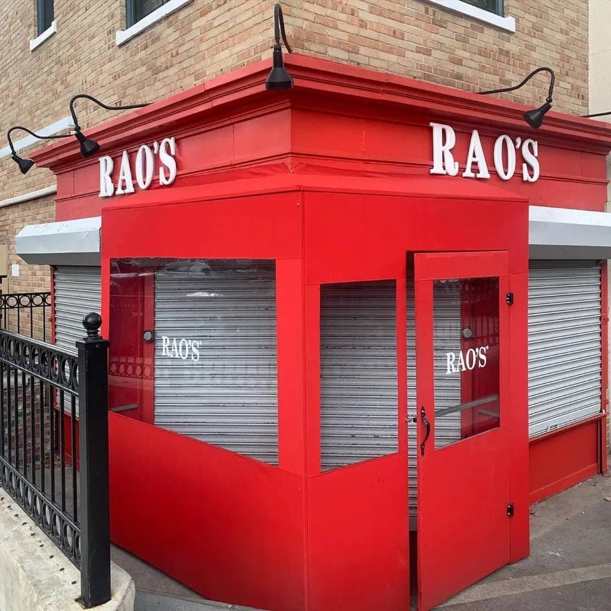Colour photograph of a small corner restaurant painted bright red, its name over the door