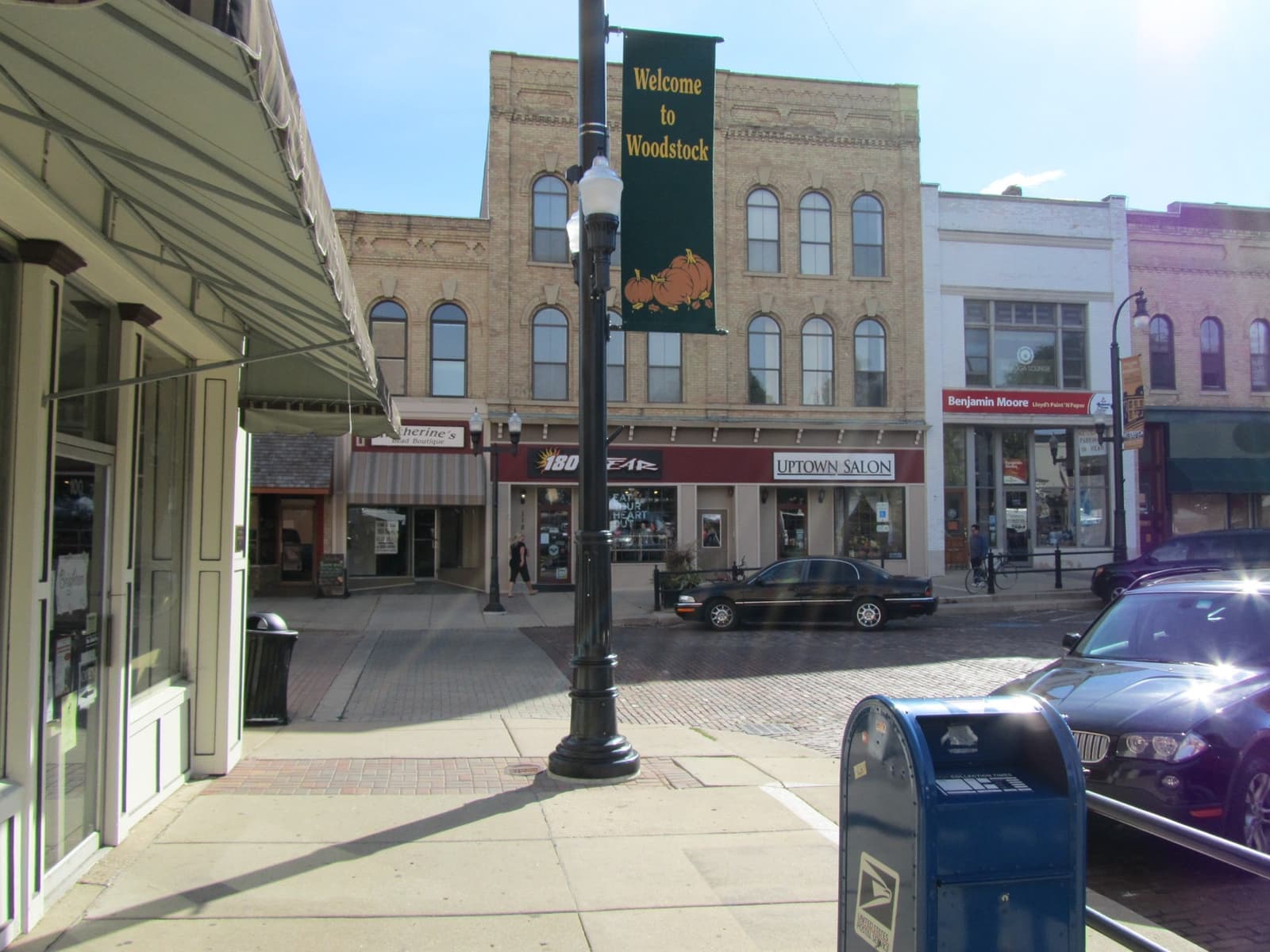 A street corner on the square with shopfronts, a lamp post and a post box