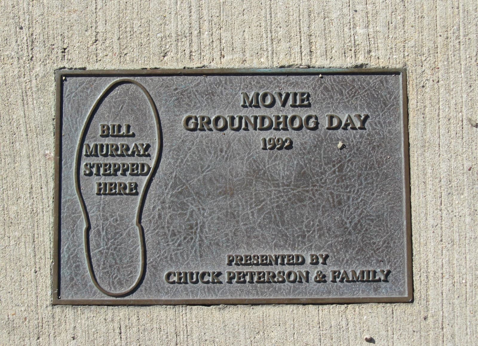 A bronze plaque set in concrete with a shoe print and the words Bill Murray stepped here