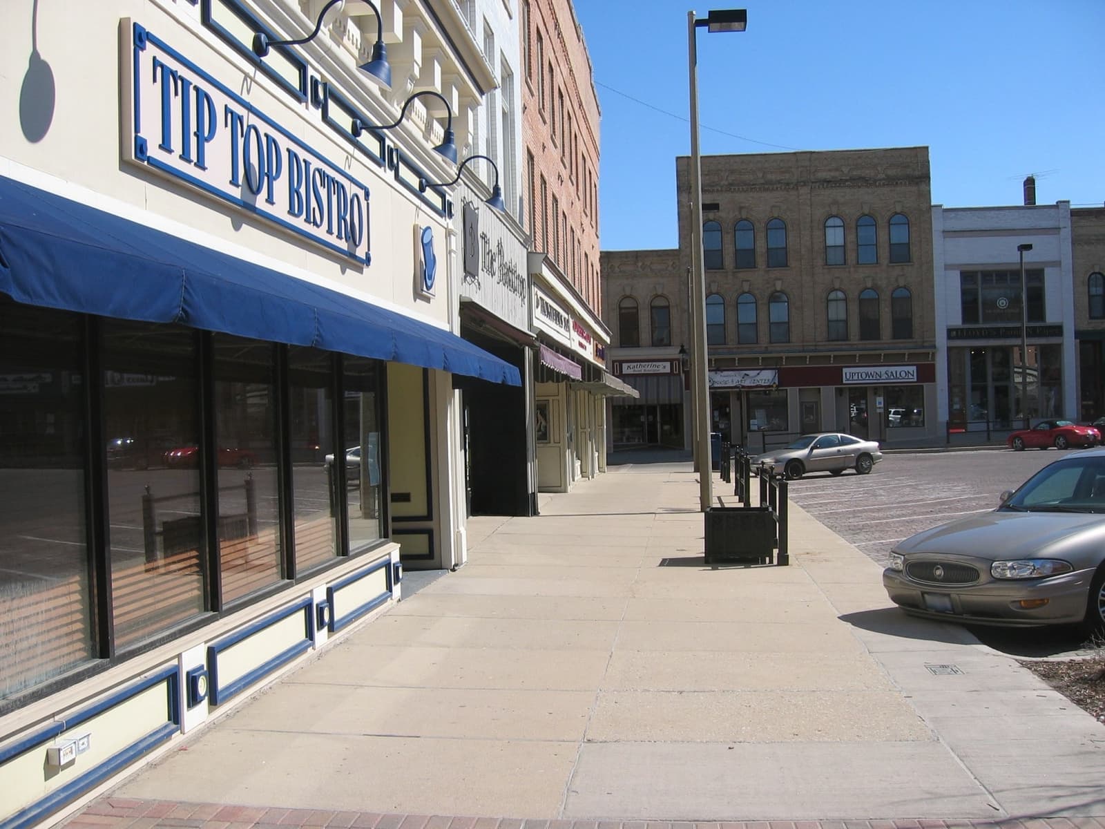 A corner shopfront with a blue awning and a Tip Top Bistro sign