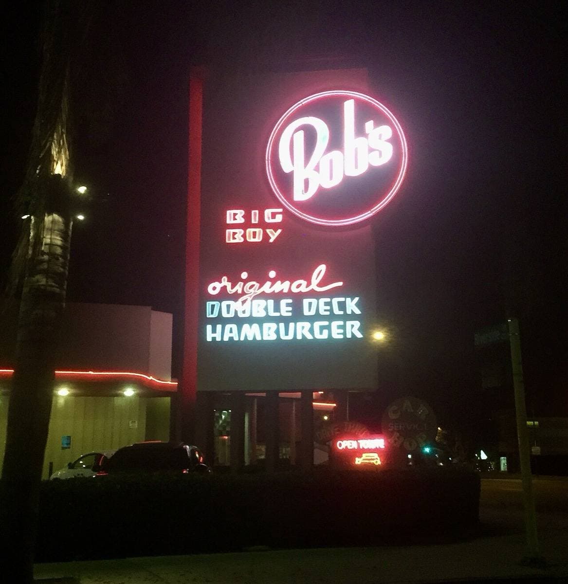A red and white neon sign glowing in the dark