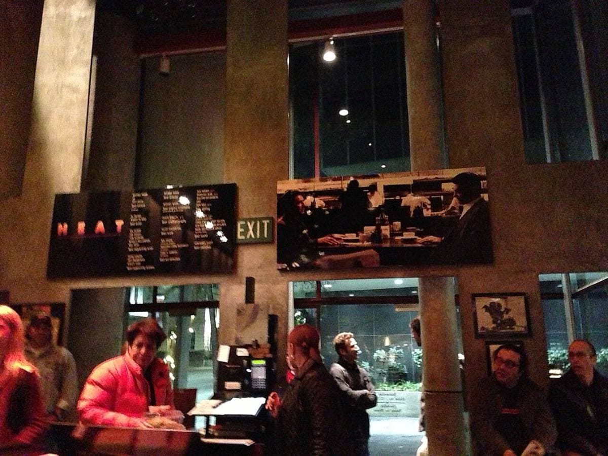 A busy restaurant interior with framed Heat posters high on a dark wall