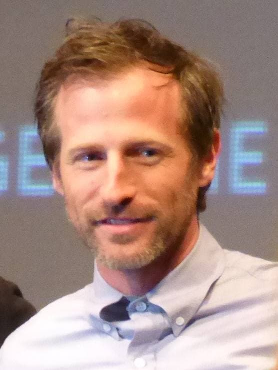 Spike Jonze smiling, in a pale blue button-down shirt