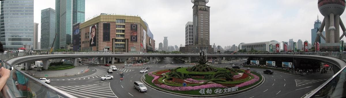 A wide raised pedestrian walkway curving between towers in Pudong