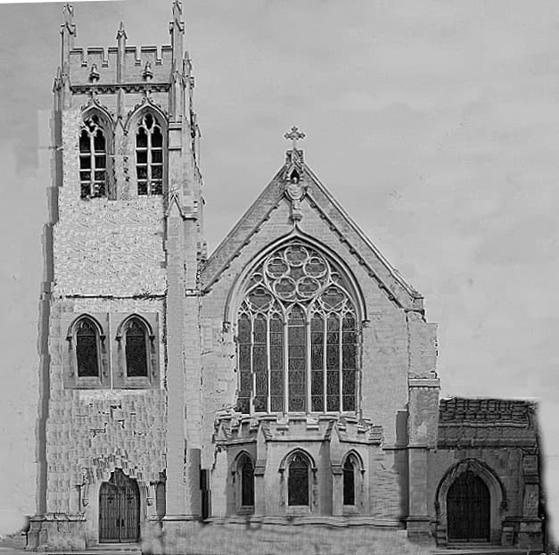 A black-and-white view of a Gothic stone church front with a square tower