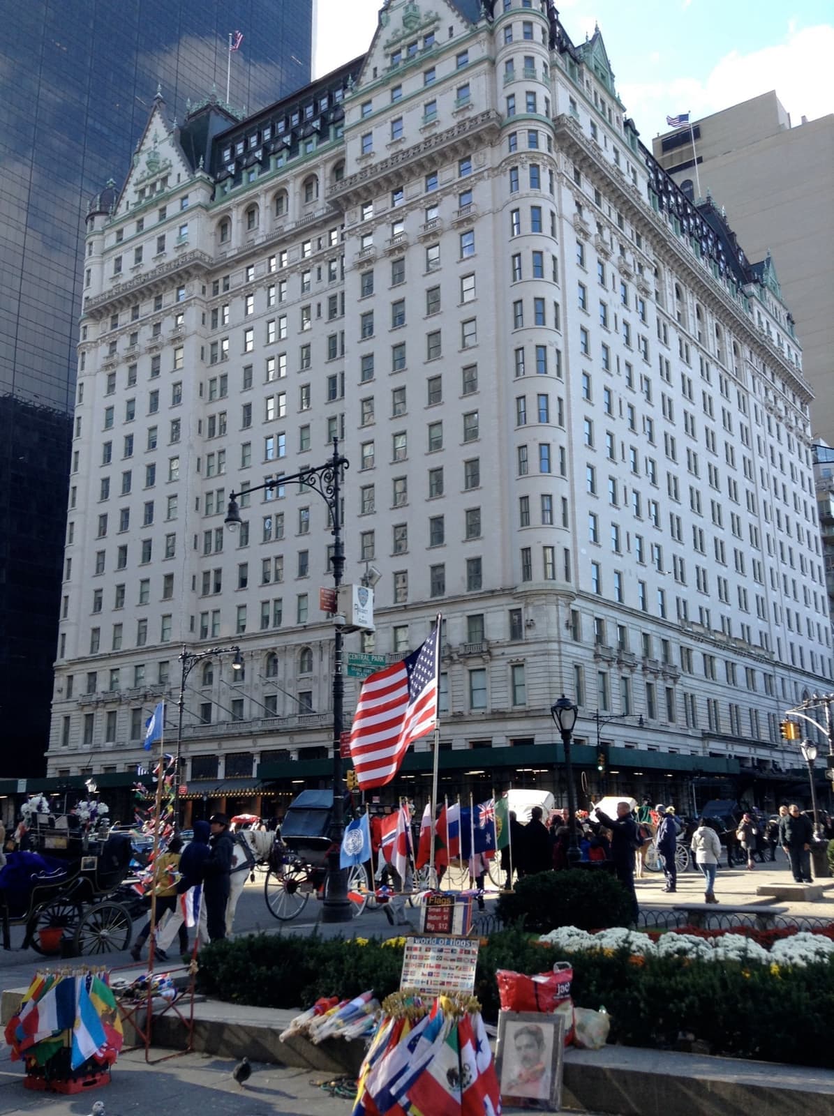 A white French-château style hotel tower with flags at its entrance