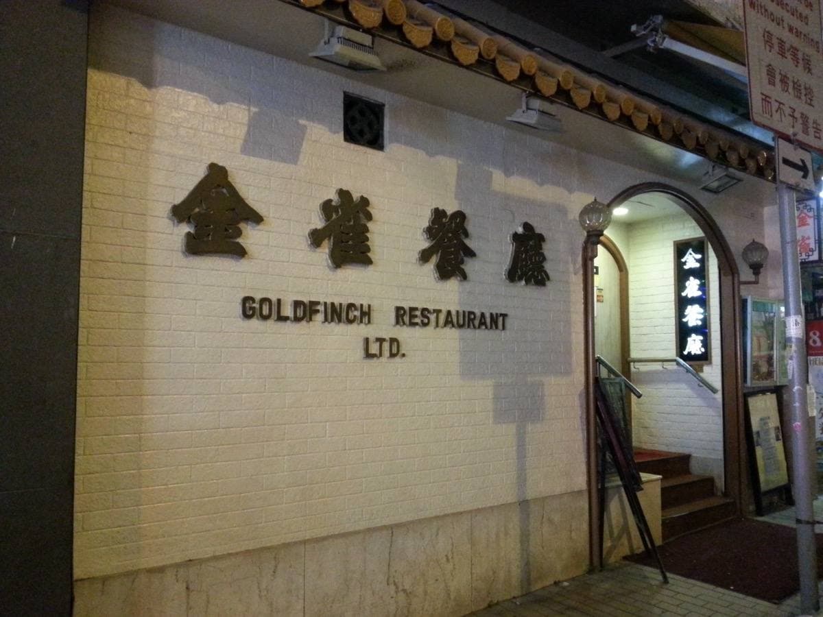 The tiled front of Goldfinch Restaurant at night, its name in gold Chinese characters