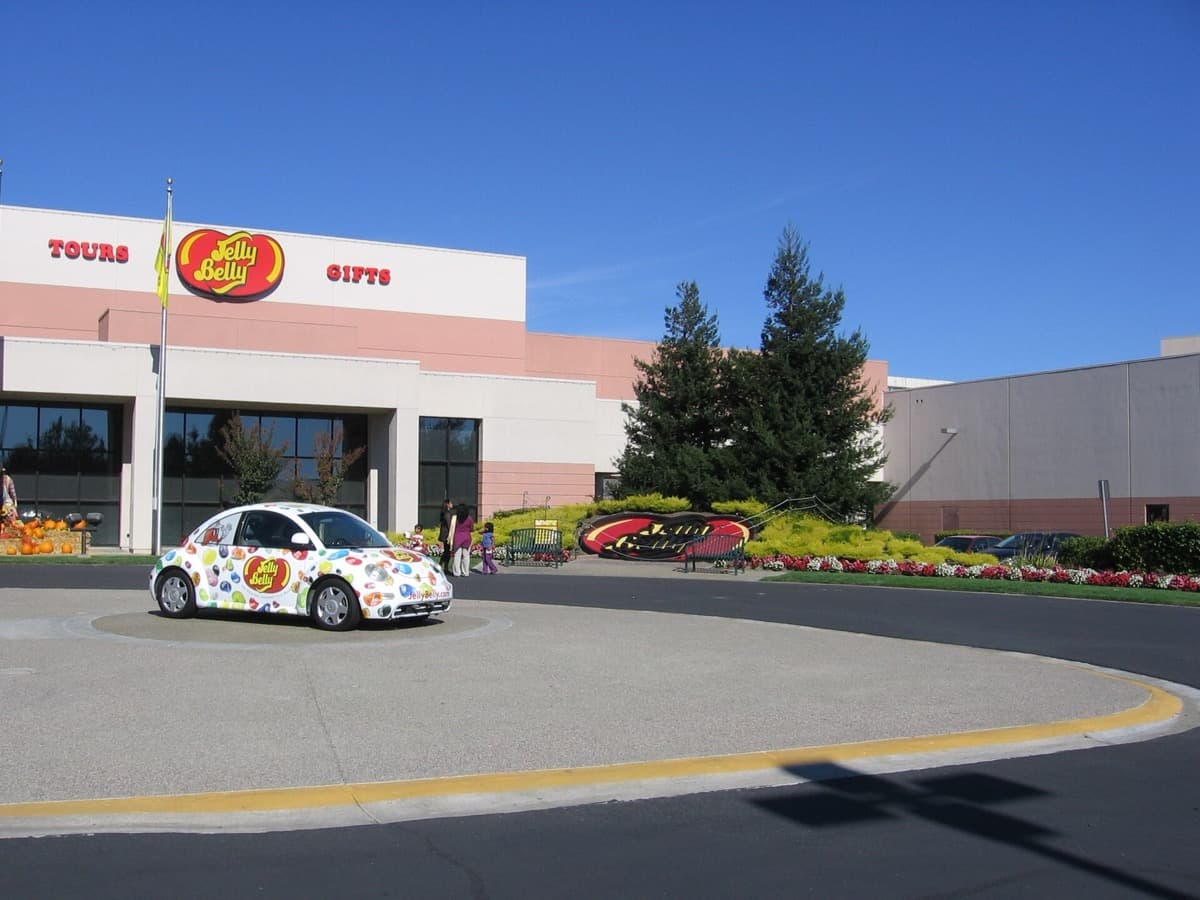 A candy factory building with a large sign and landscaped entrance