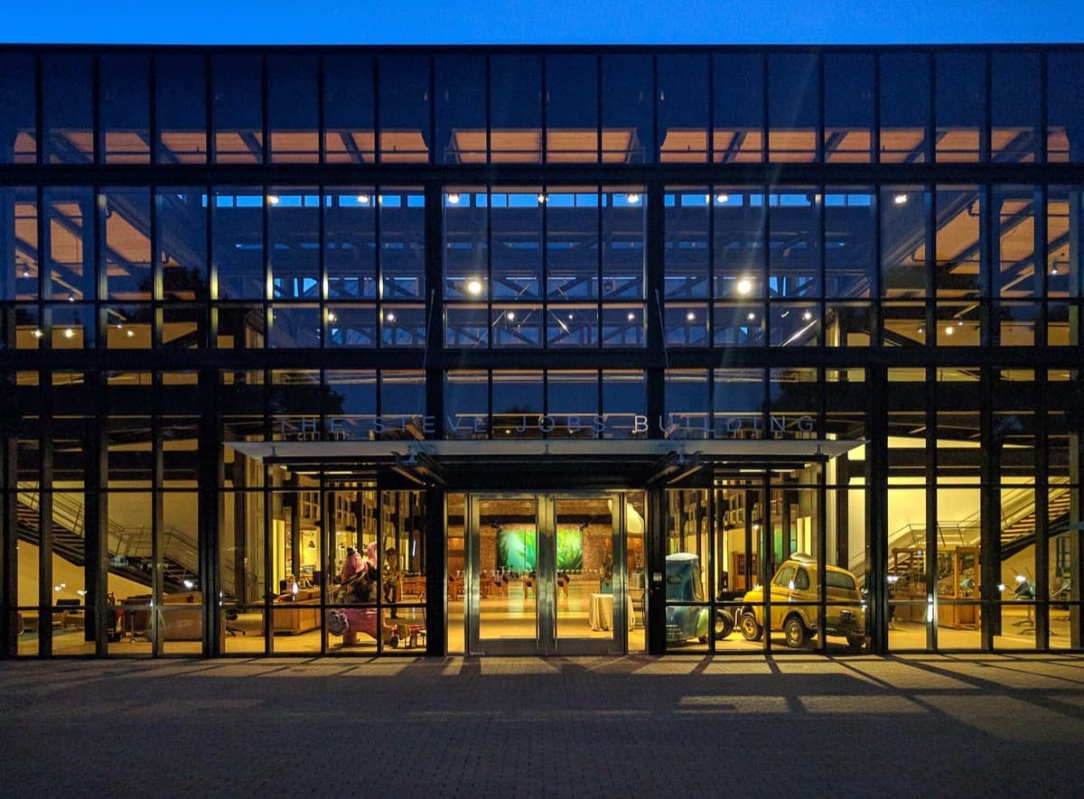 A large modern studio building with lit windows at dusk