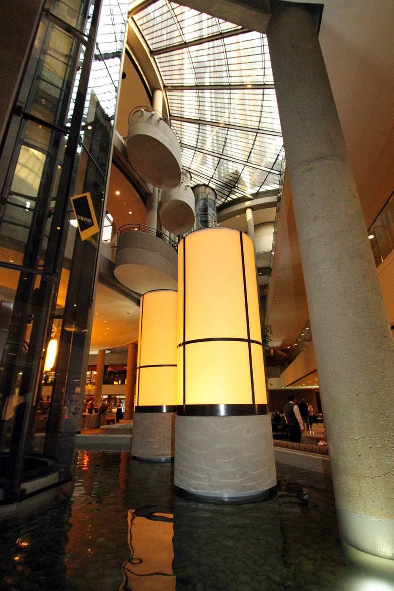 Tall concrete columns and hanging lights inside a hotel atrium