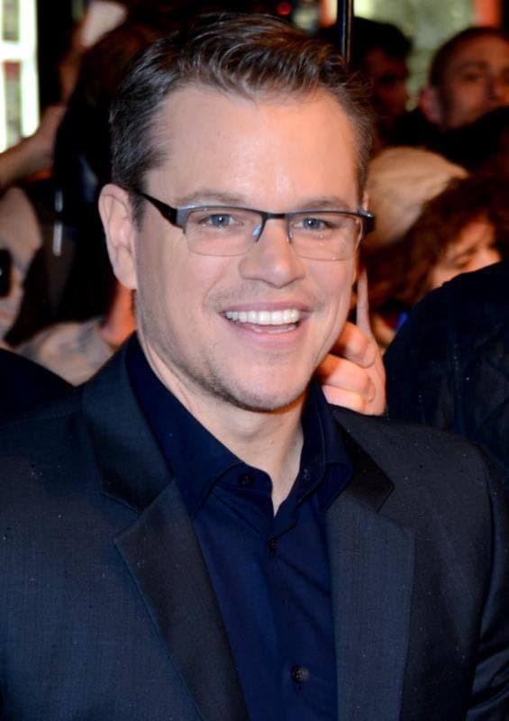 Matt Damon in glasses and a dark jacket, smiling