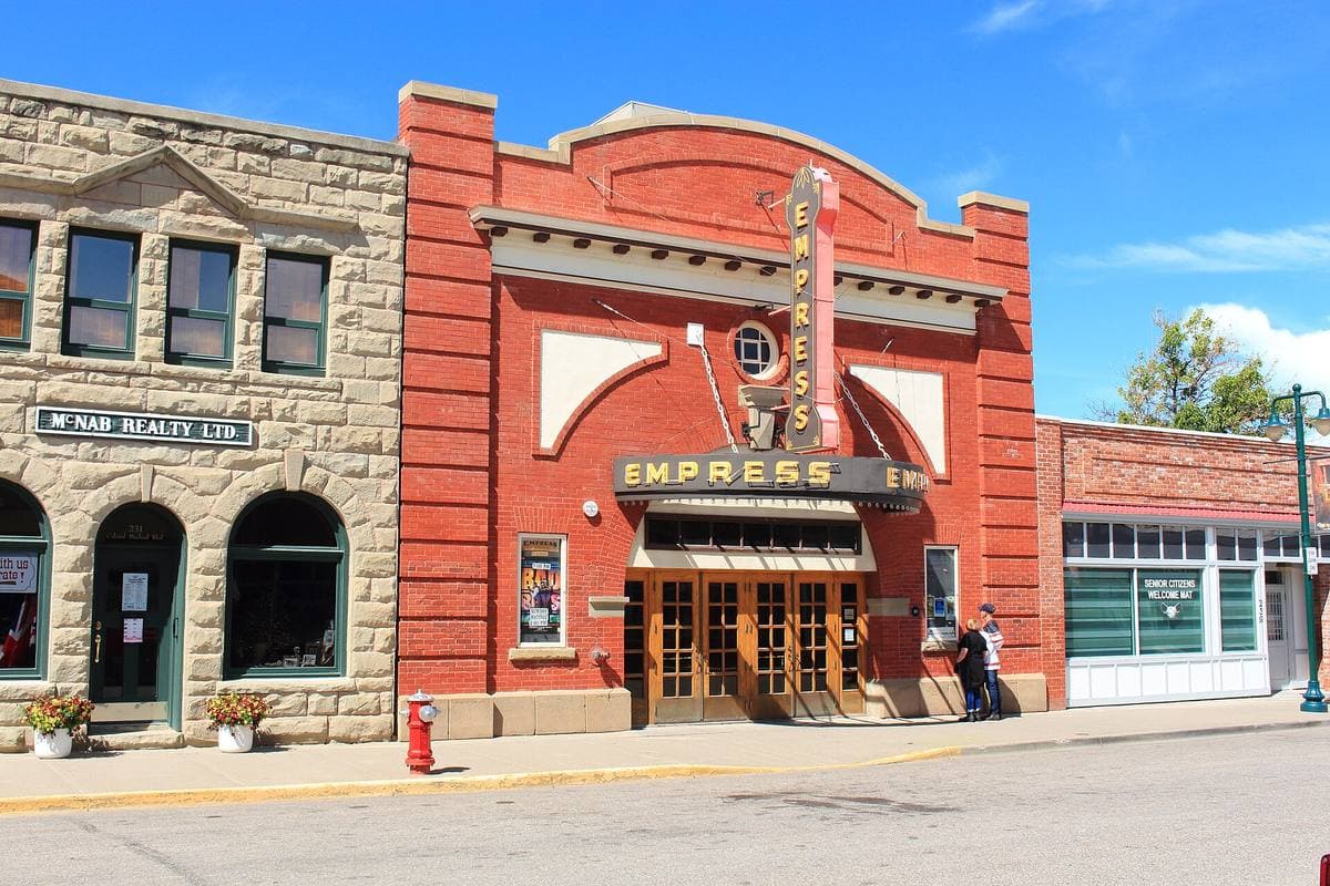 A red brick theatre with a marquee and arched windows