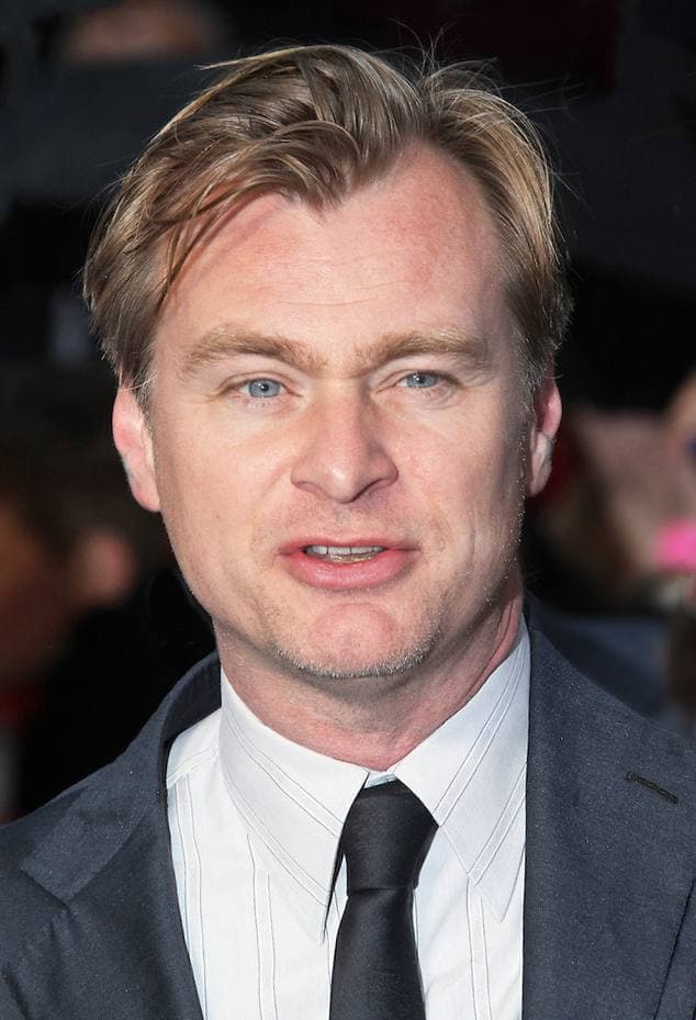 Christopher Nolan in a dark suit and tie