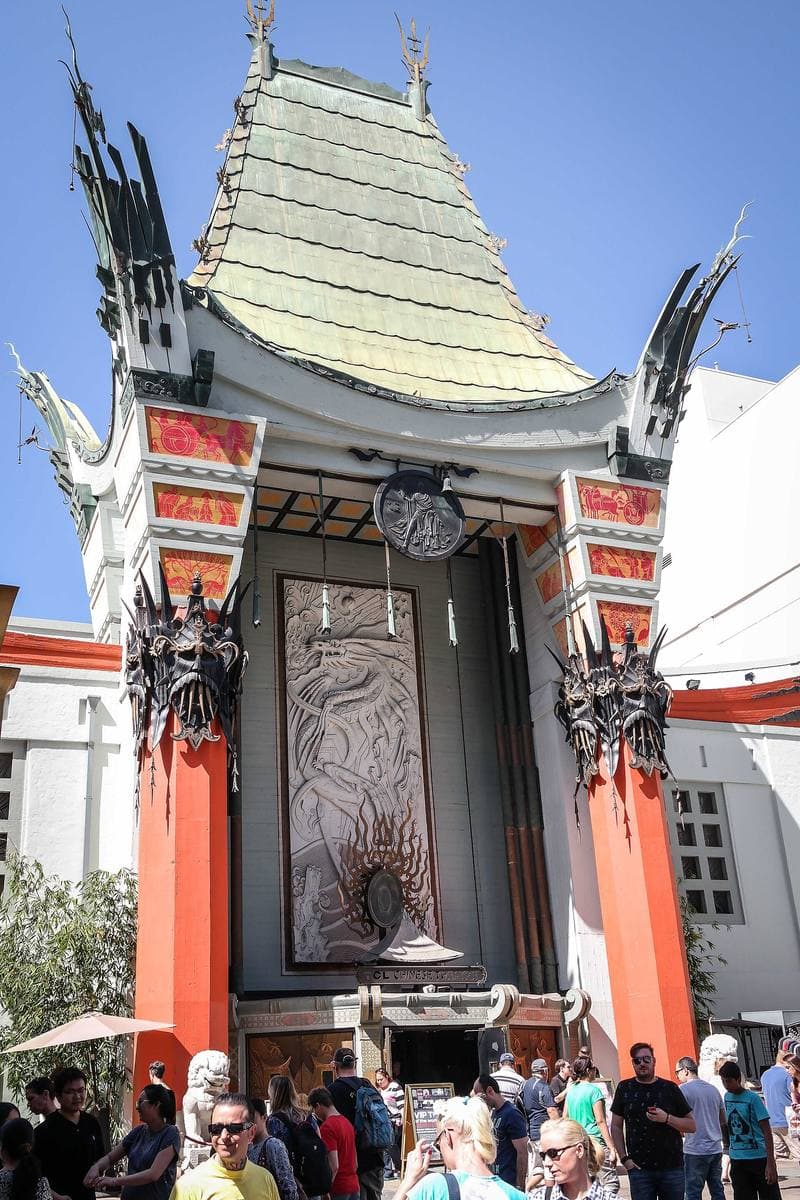 The ornate red and green pagoda facade of a cinema with a crowd in the forecourt