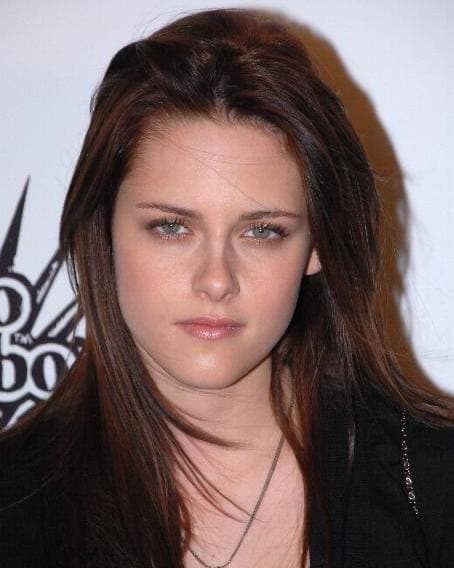 Kristen Stewart with long dark hair, looking at the camera
