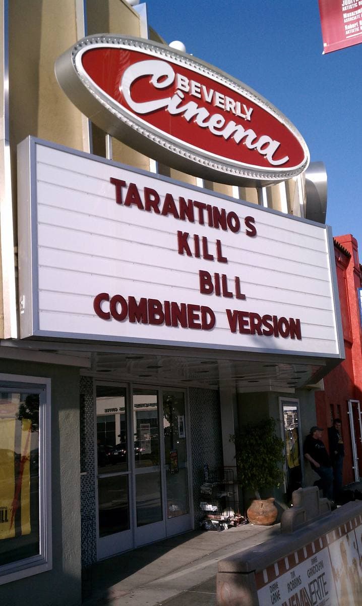 A cinema marquee reading Tarantino’s Kill Bill combined version under a red oval sign