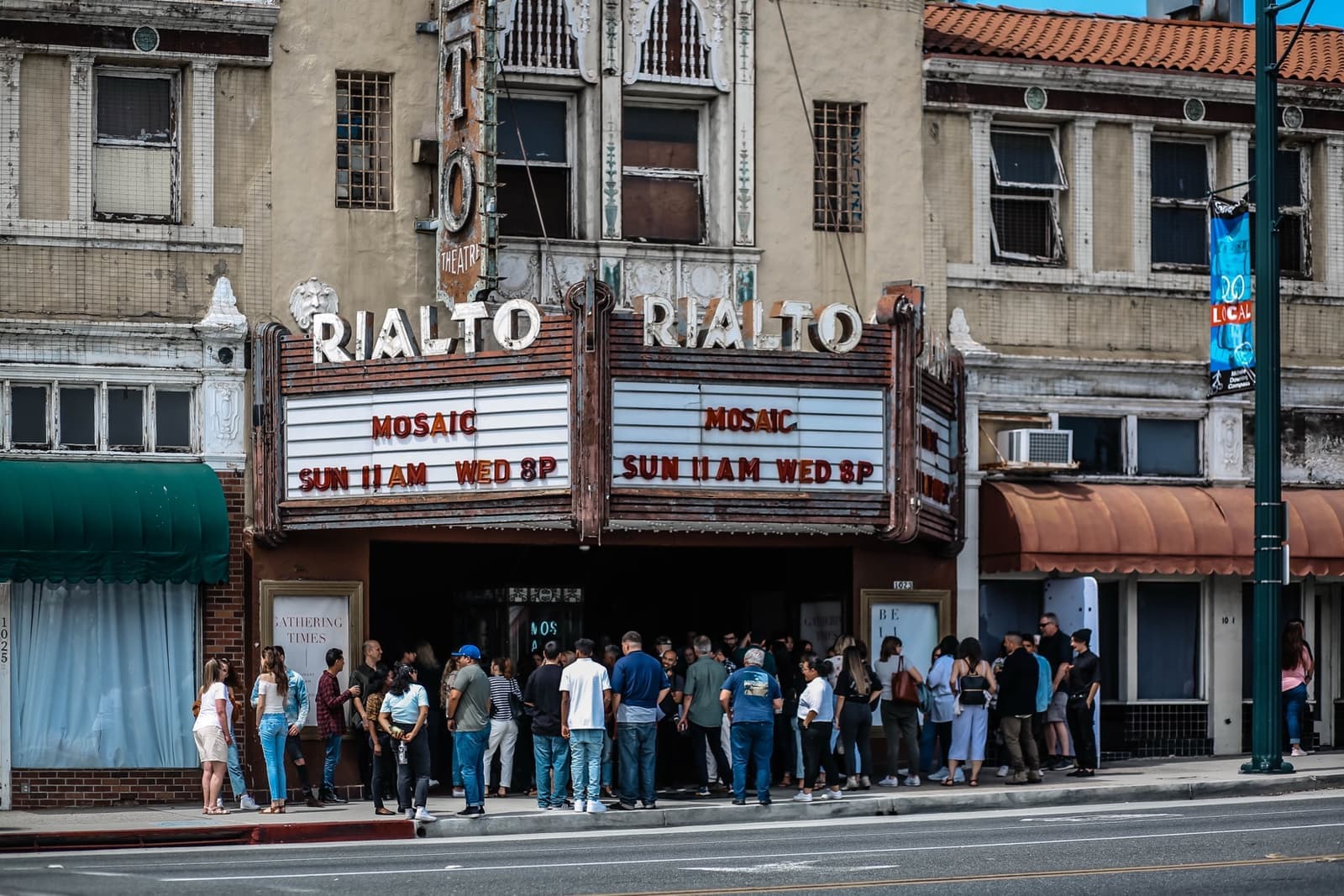 The Rialto Theatre's marquee and front on Fair Oaks Avenue with people gathered outside