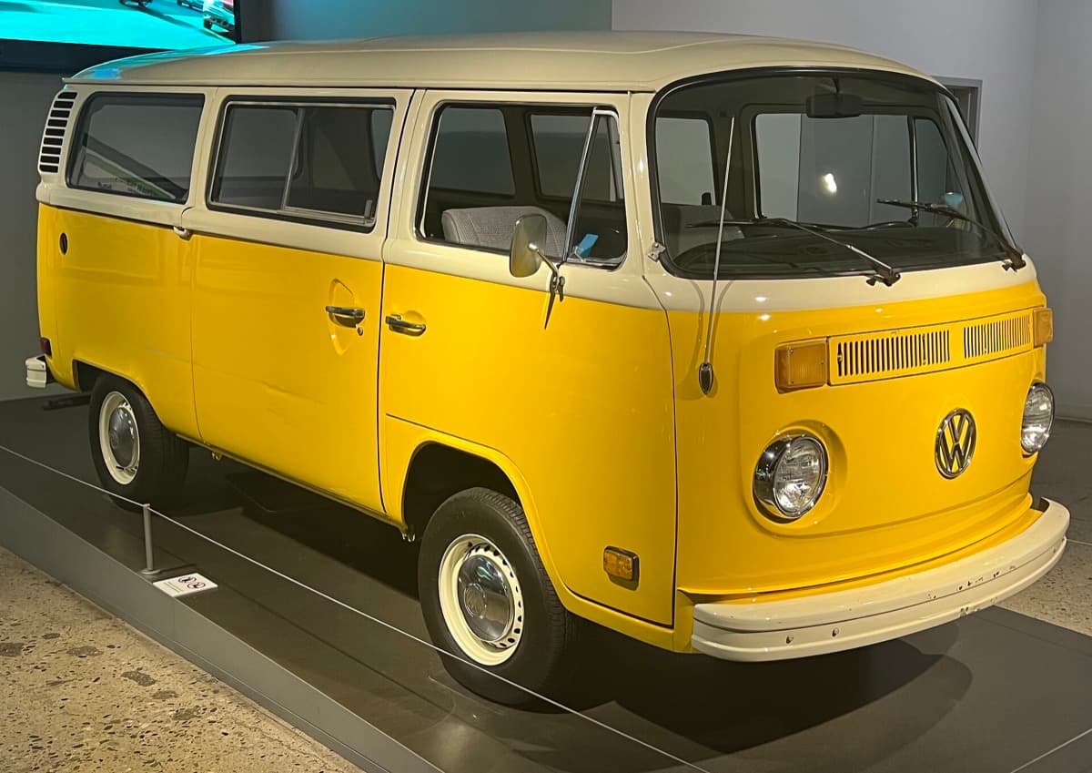 A yellow 1979 Volkswagen Type 2 bus parked indoors in a museum
