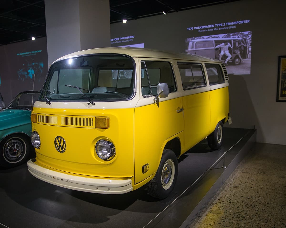 The yellow film bus seen from the front quarter inside a gallery