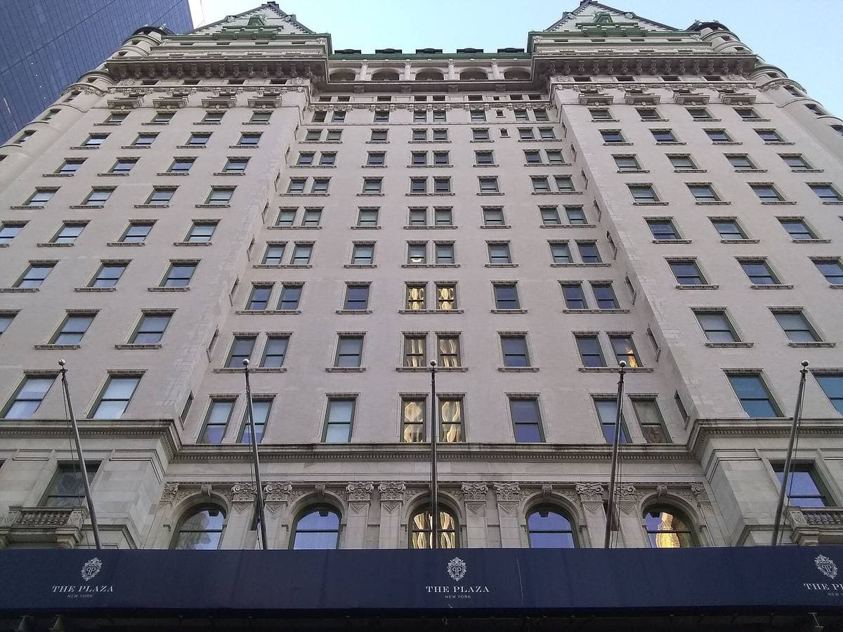 The white facade of the Plaza Hotel with green copper roofs