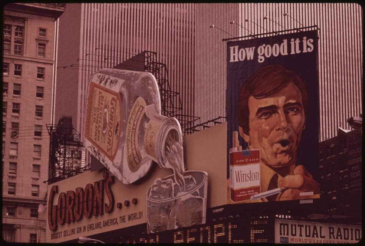 Giant painted billboards above Times Square: a gin bottle and a smoking man