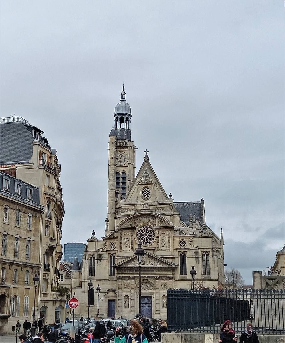 The tall Gothic-Renaissance facade of Saint-Étienne-du-Mont under a grey sky, with its bell tower and a square in front