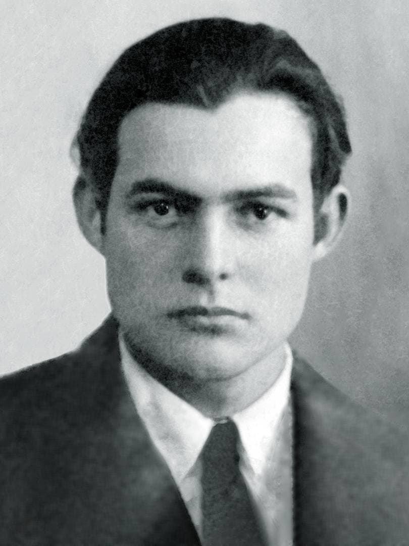 A black-and-white head-and-shoulders photograph of a young Ernest Hemingway in a jacket and tie