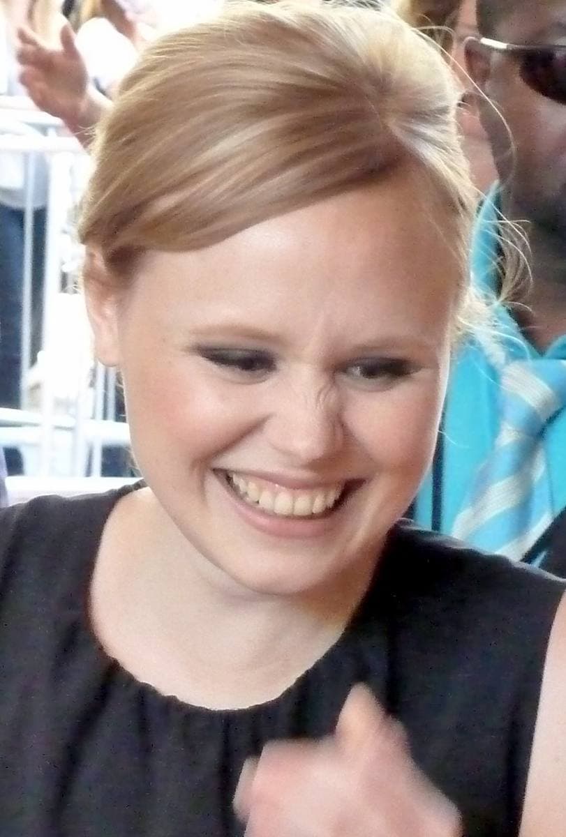 Alison Pill laughing, her fair hair pinned back