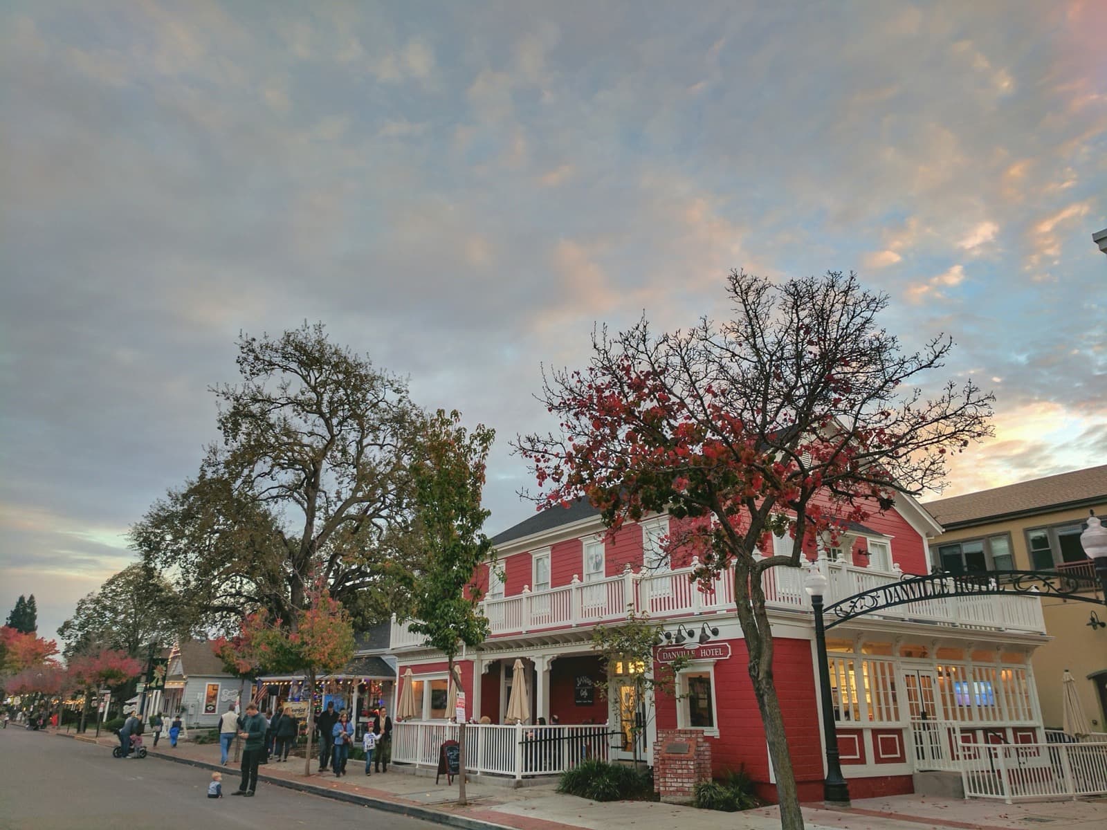 A small-town main street with a red clapboard hotel and autumn trees