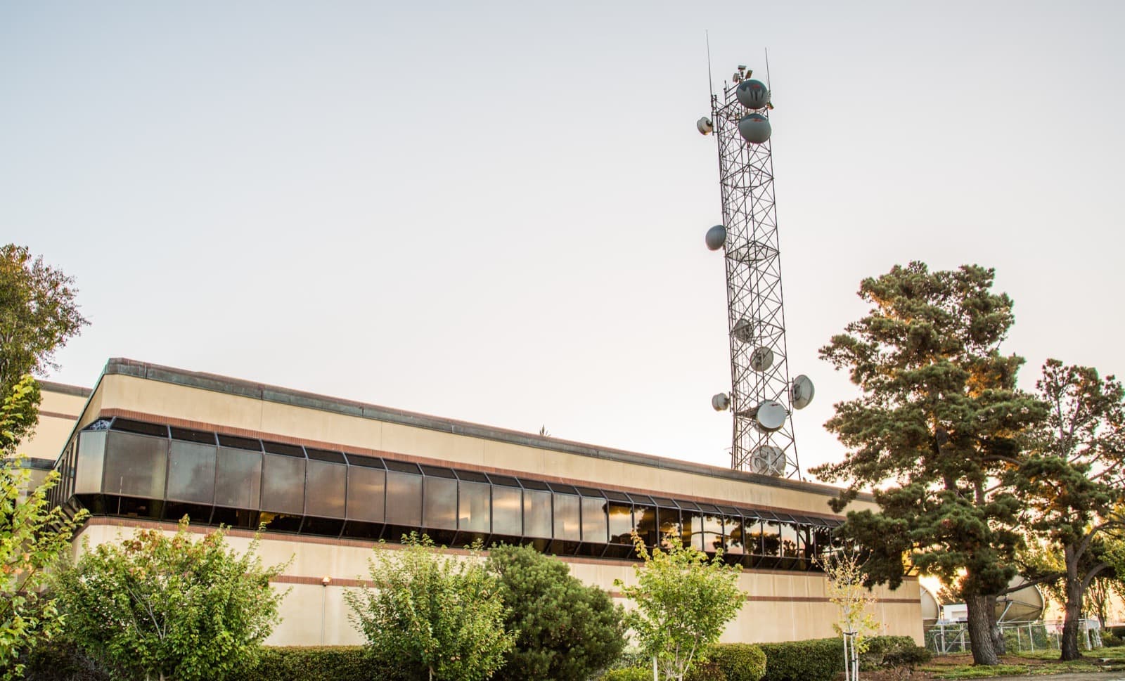 A low studio building with a lattice broadcast mast behind it
