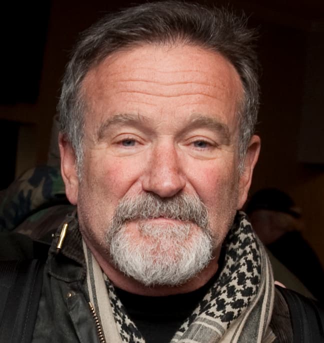 Robin Williams with a grey beard and a scarf, smiling gently