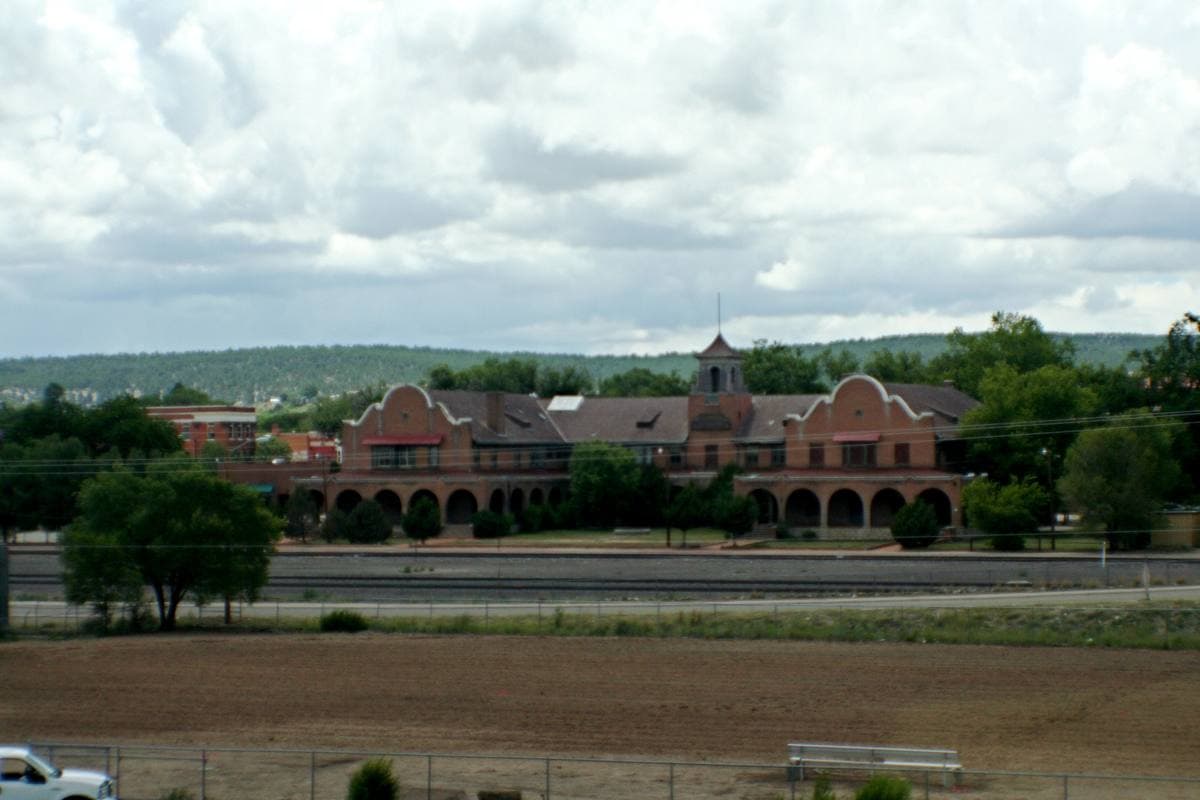 A long low Mission-style station building beyond the tracks