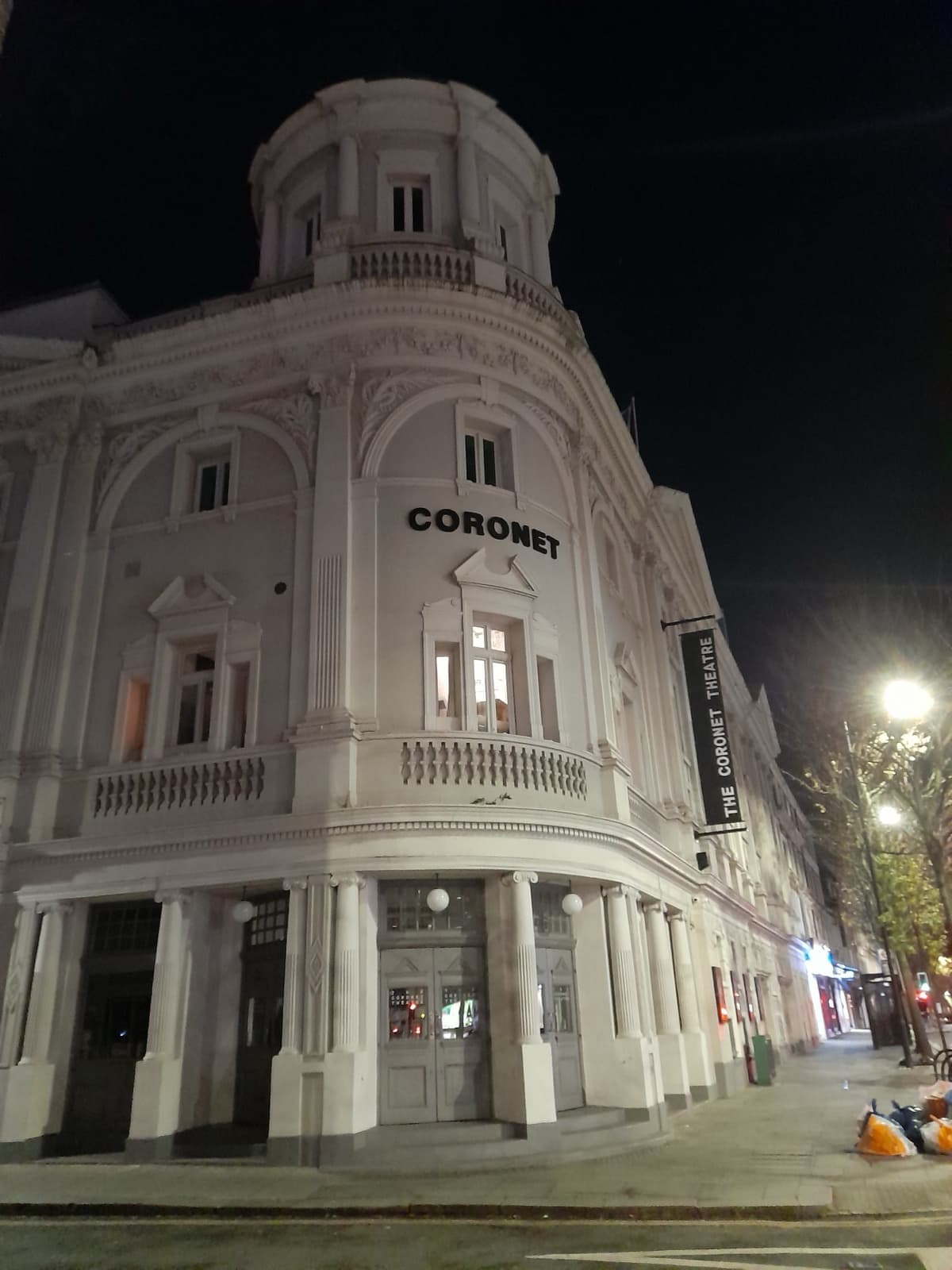 The lit front of the Coronet Theatre on Notting Hill Gate at night