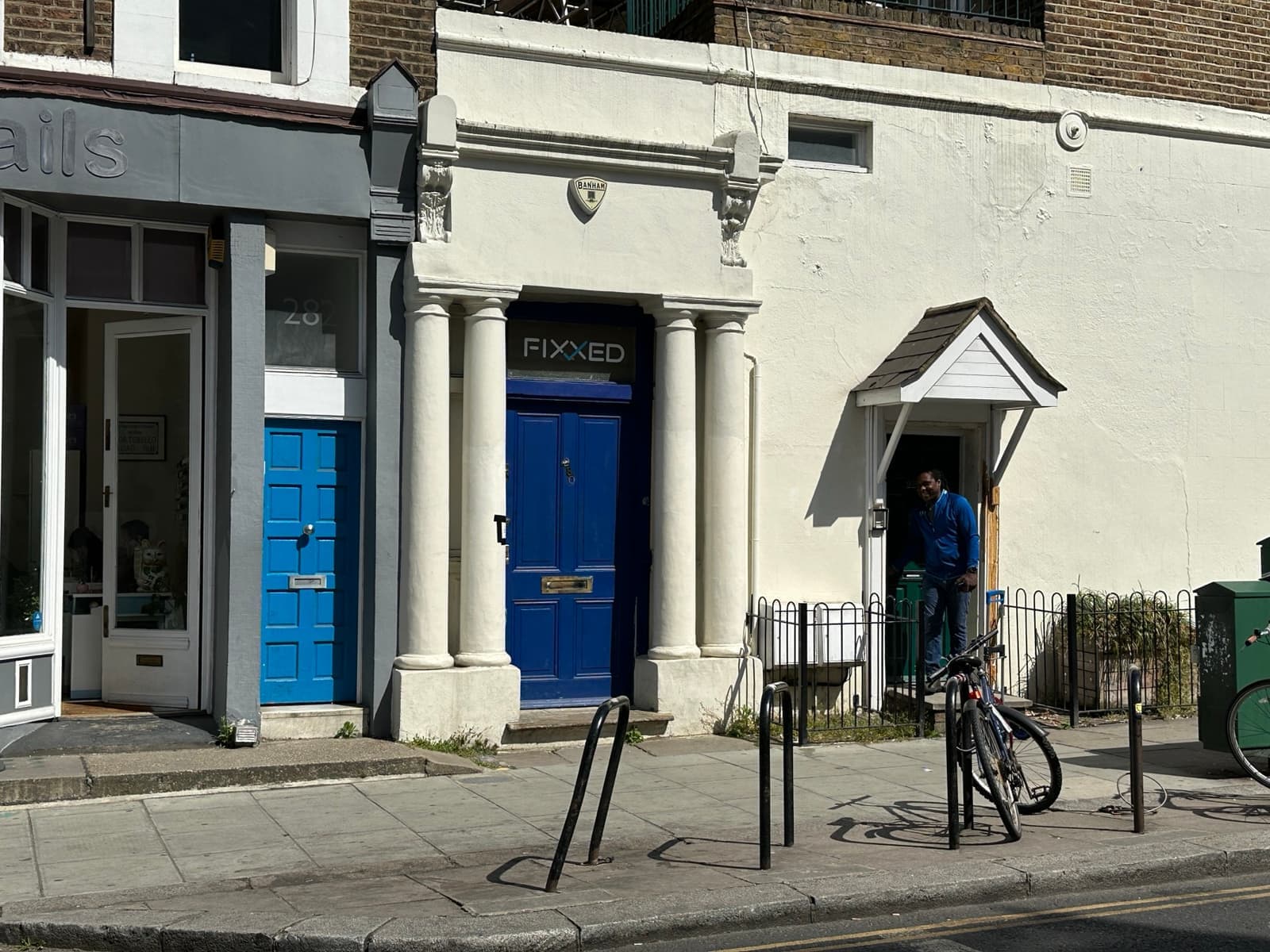 A blue front door with a brass number in a London terrace