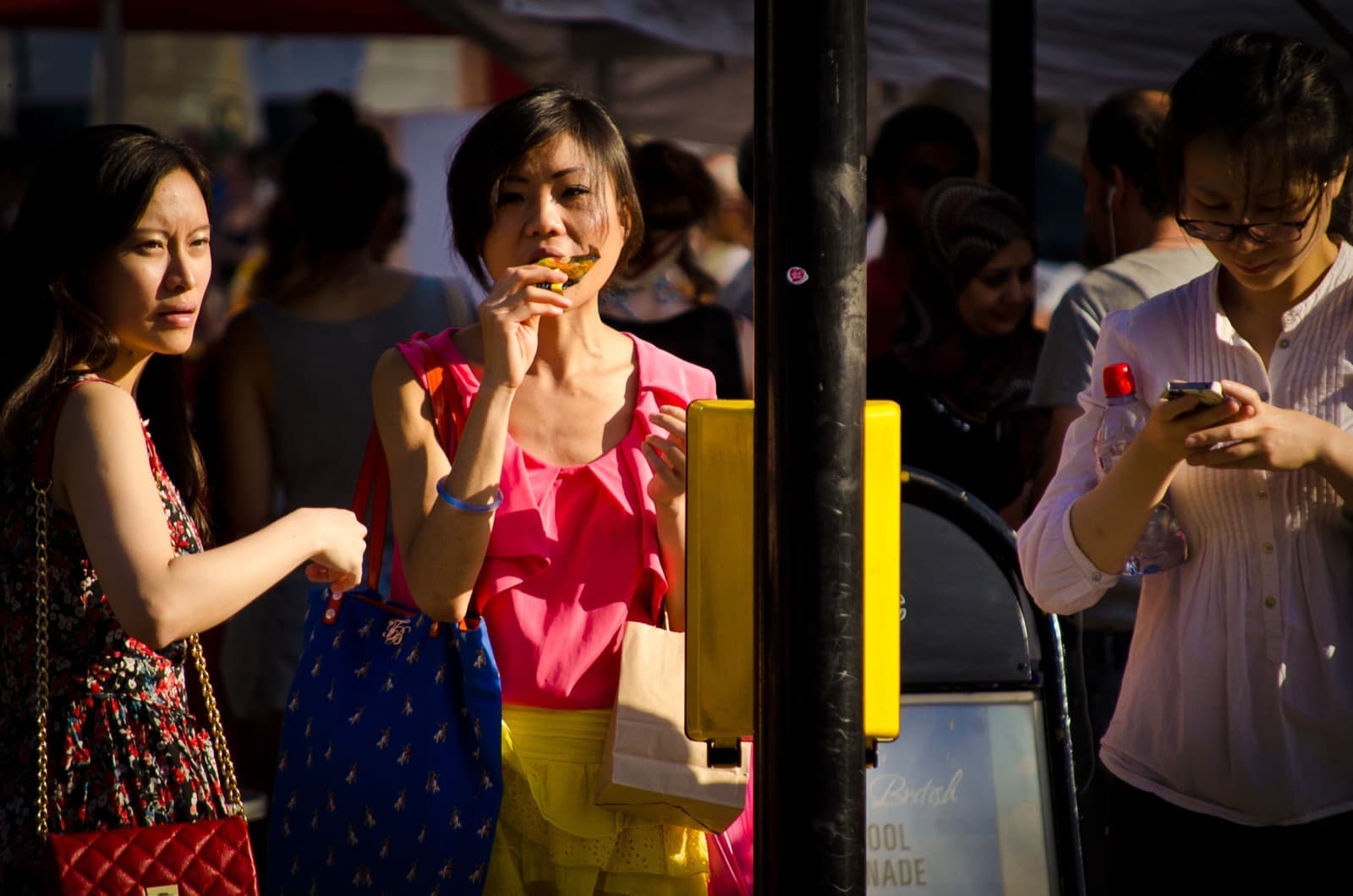 Crowds walking between stalls on Portobello Road in sunshine