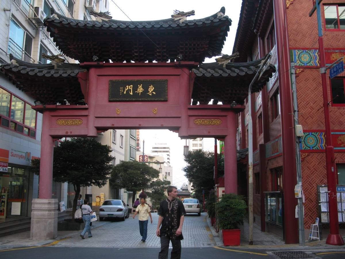 A red and green painted gate over a Busan street
