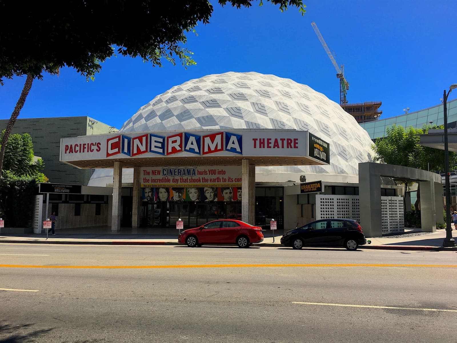 The white geodesic Cinerama Dome with a period marquee under a blue sky