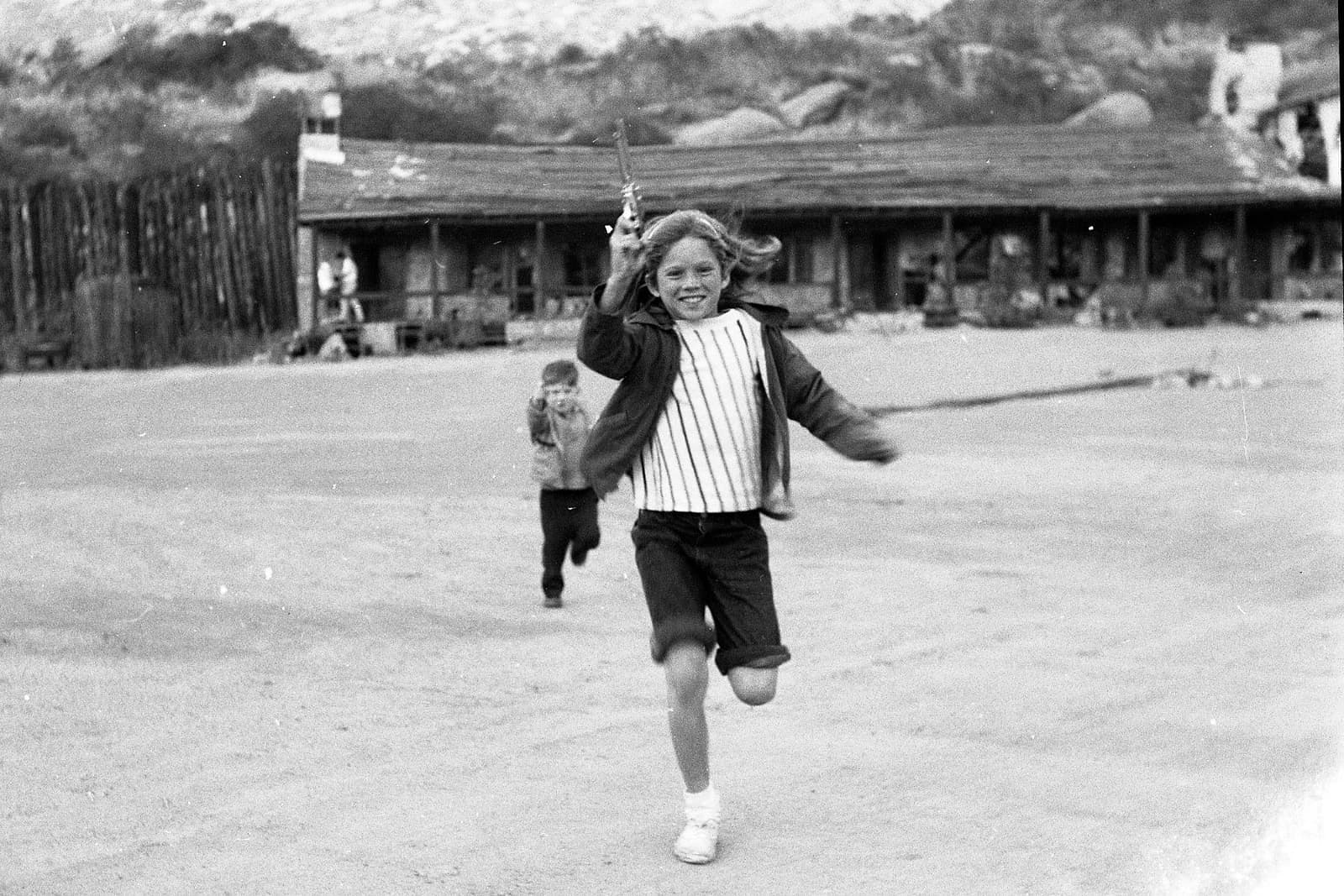 Children playing among western sets at a movie ranch