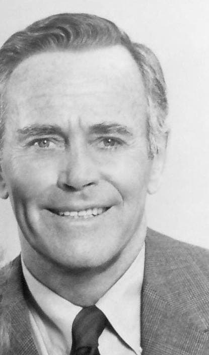 Henry Fonda smiling in a suit and striped tie, grey hair, black and white