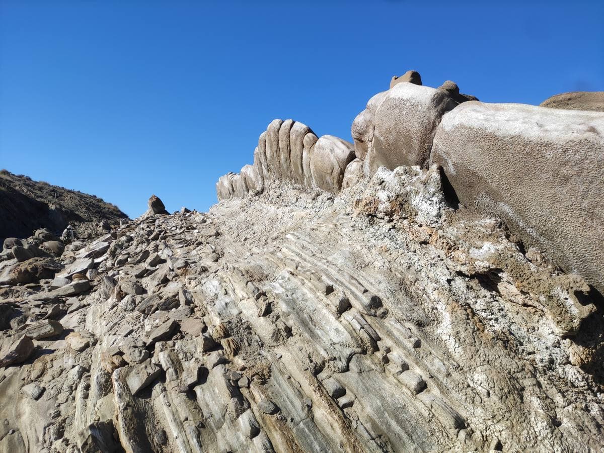 Grey eroded ridges of the desert under a hard blue sky