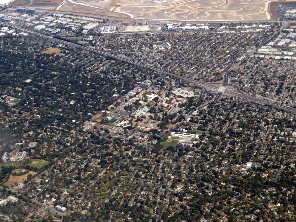 Aerial view of low hospital buildings among trees