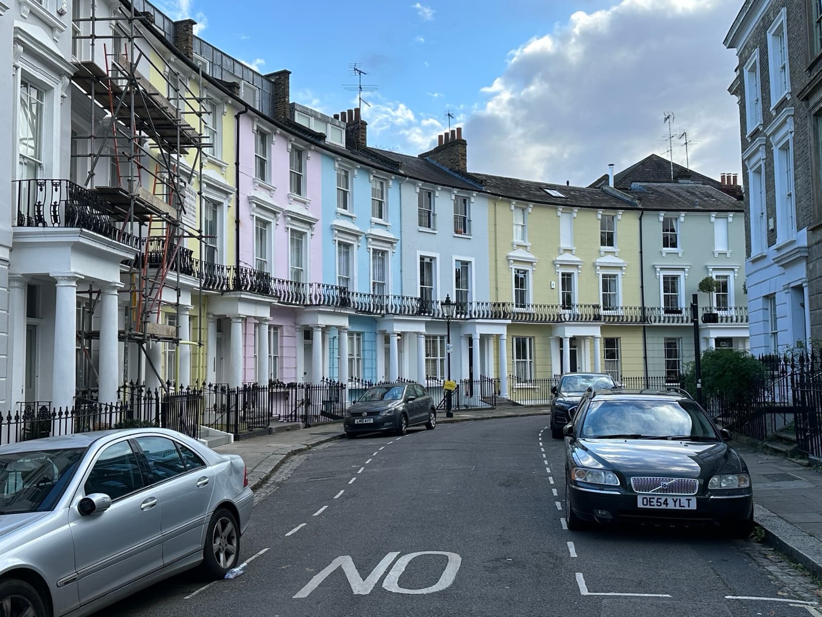 A curved terrace of pastel-painted Victorian houses on Chalcot Crescent