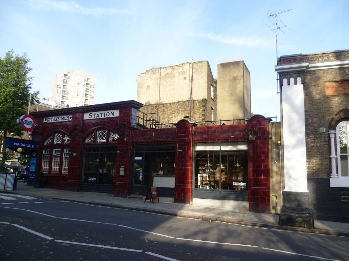 A low station front in oxblood-red glazed tiles with arched windows and the word STATION over the door
